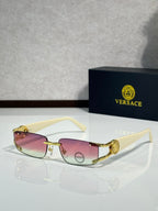 Gold-tone sunglasses with pink tinted lenses and light cream arms