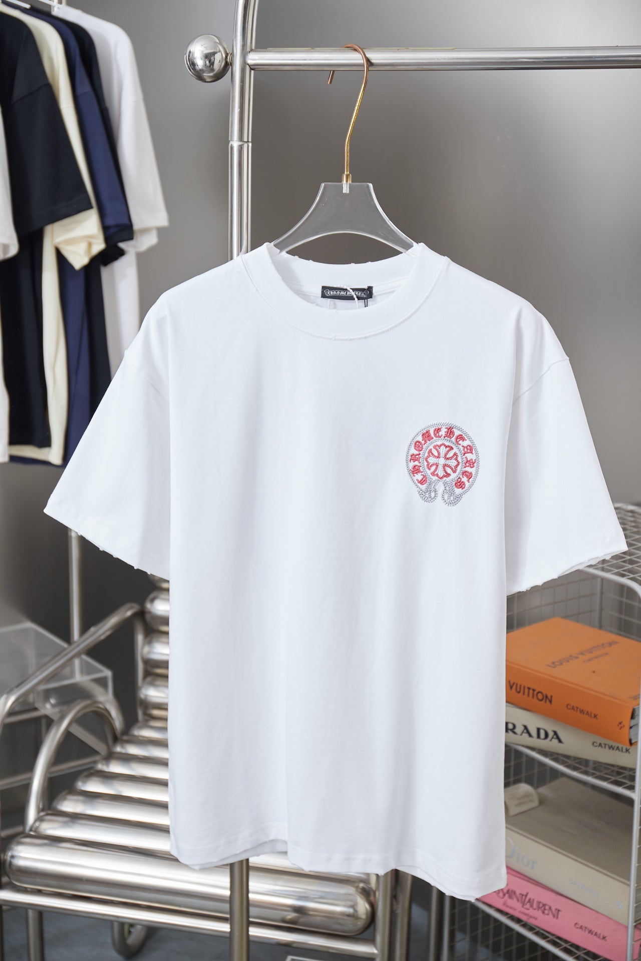 White short-sleeve T-shirt with small red crest logo on left chest