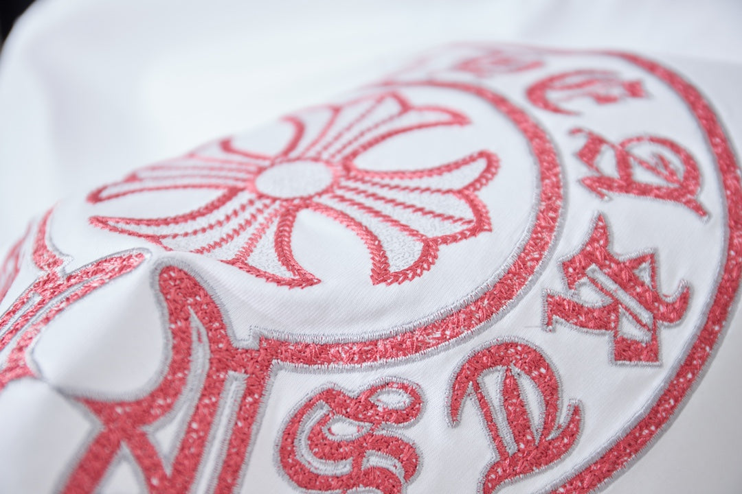 Red embroidered floral crest detail on white T-shirt