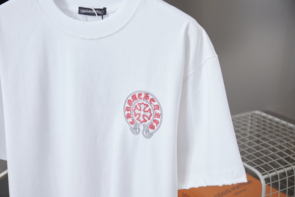 White T-shirt close-up with small red crest logo on chest