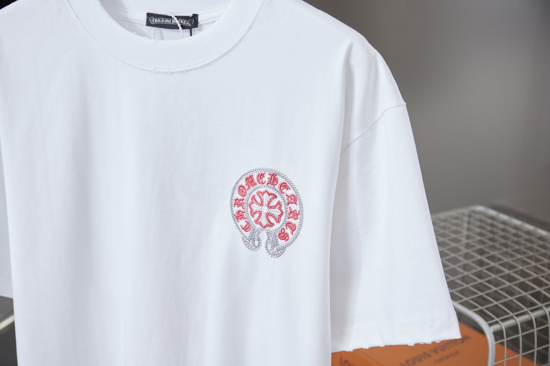 White T-shirt close-up with small red crest logo on chest