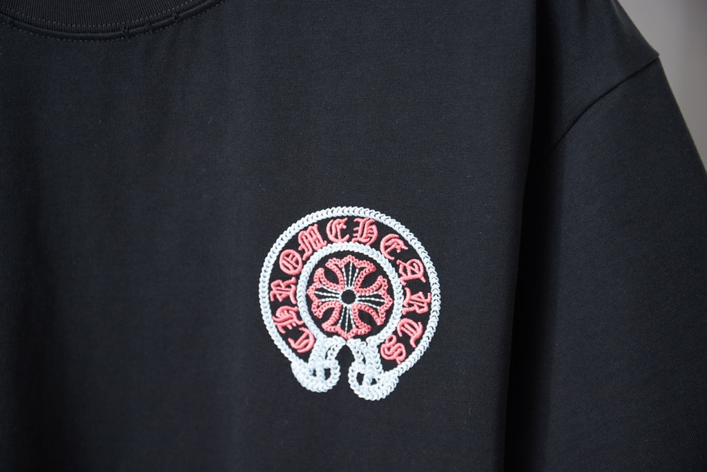 Close-up of red-and-white circular chest graphic on a black T-shirt