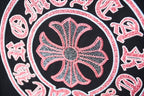 Close-up of pink flower emblem on dark T-shirt with dotted texture and white outline.