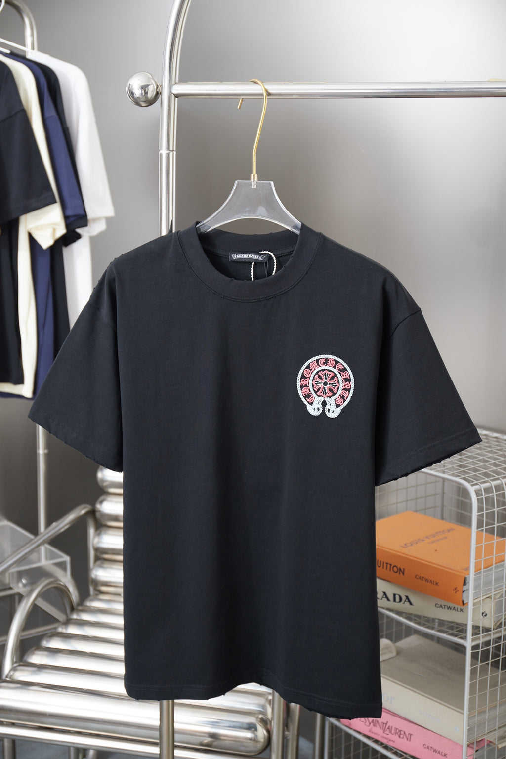 Black short-sleeve T-shirt with small red-and-white circular chest graphic