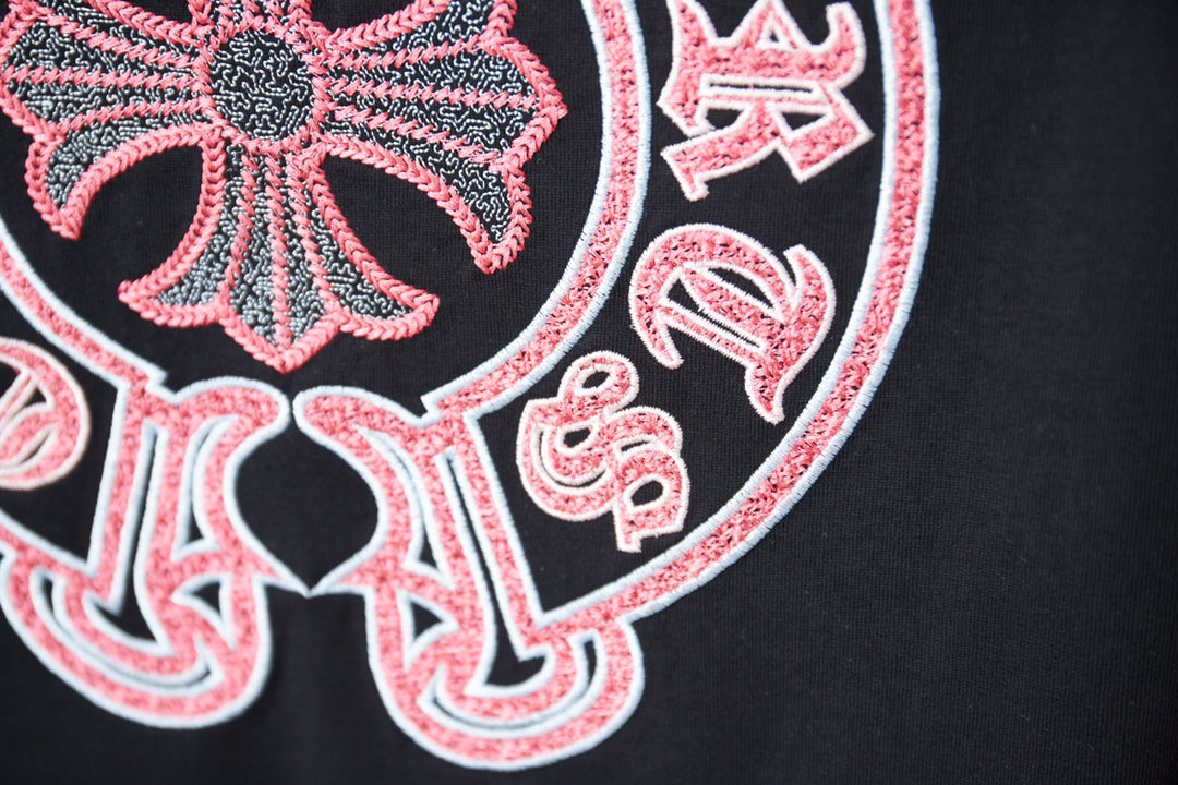 Close-up of red-and-white circular graphic details on a black T-shirt