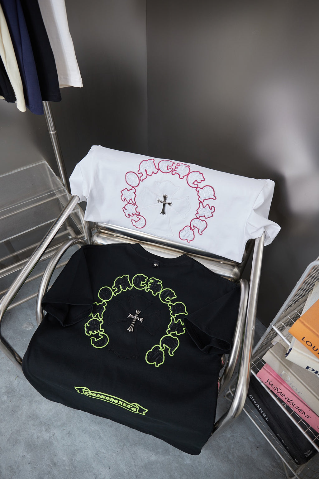 Folded white and black T-shirts with neon green and pink circular cross graphics