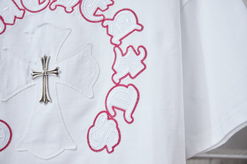 White T-shirt close-up of silver cross and red ring embroidery
