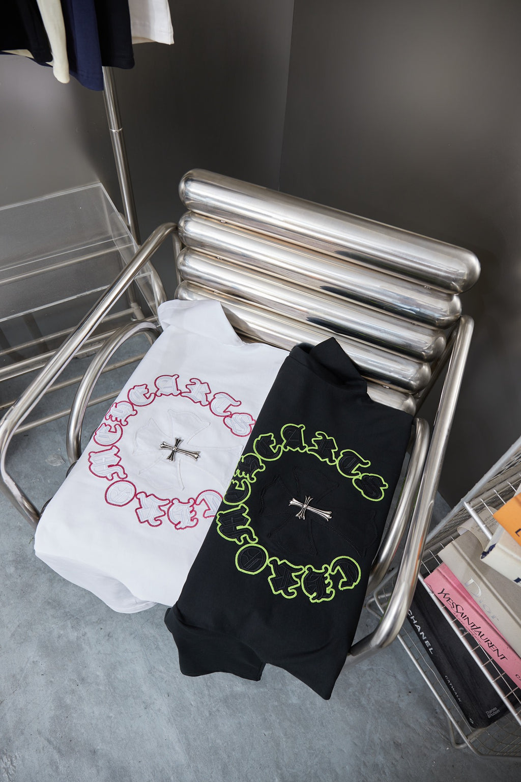 Folded white and black T-shirts with ring embroidery and silver cross