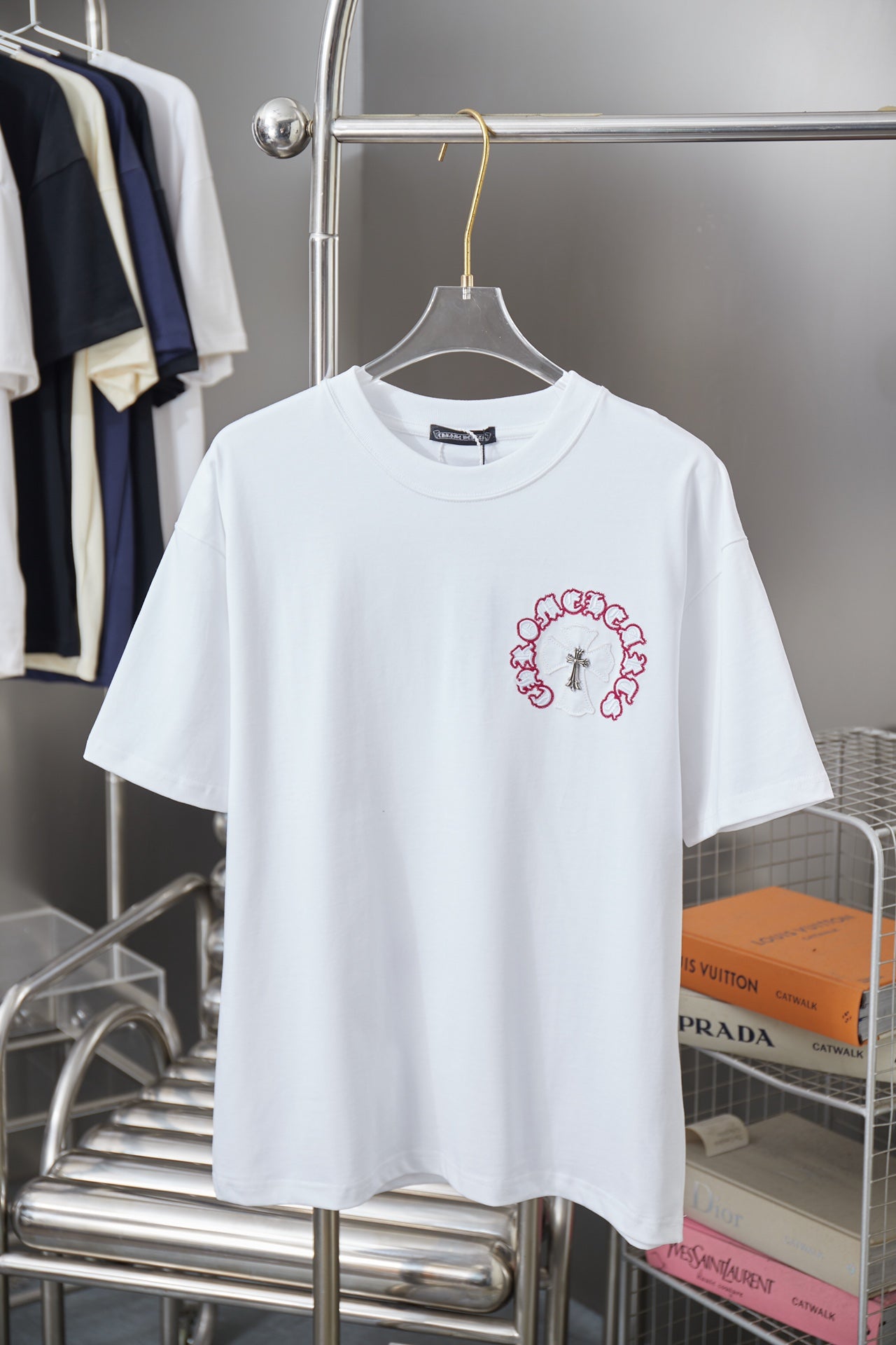 White short-sleeve T-shirt with red embroidered ring graphic and cross