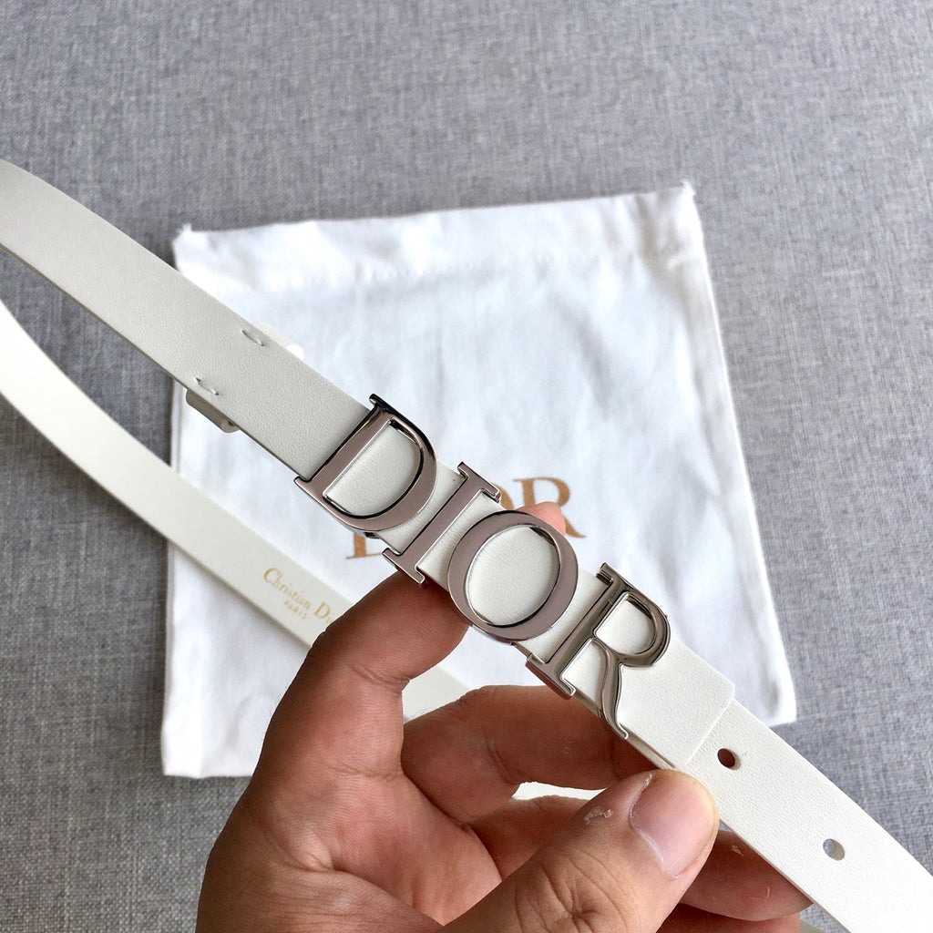 Dior belt with silver-tone buckle detail and light ivory strap, shown in hand