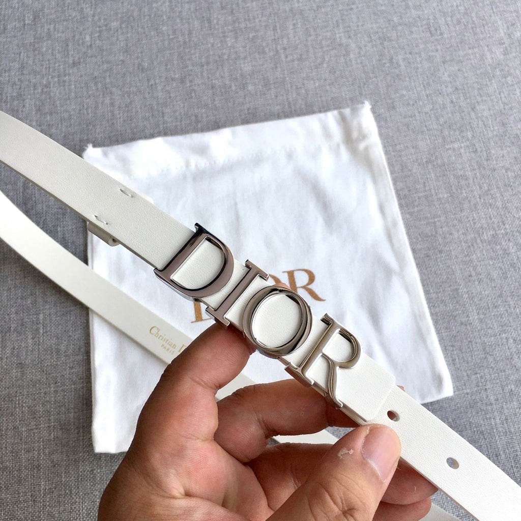 Dior belt close-up with silver-tone buckle and light ivory leather strap