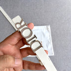 Dior belt end with prong and light ivory strap, silver-tone buckle detail