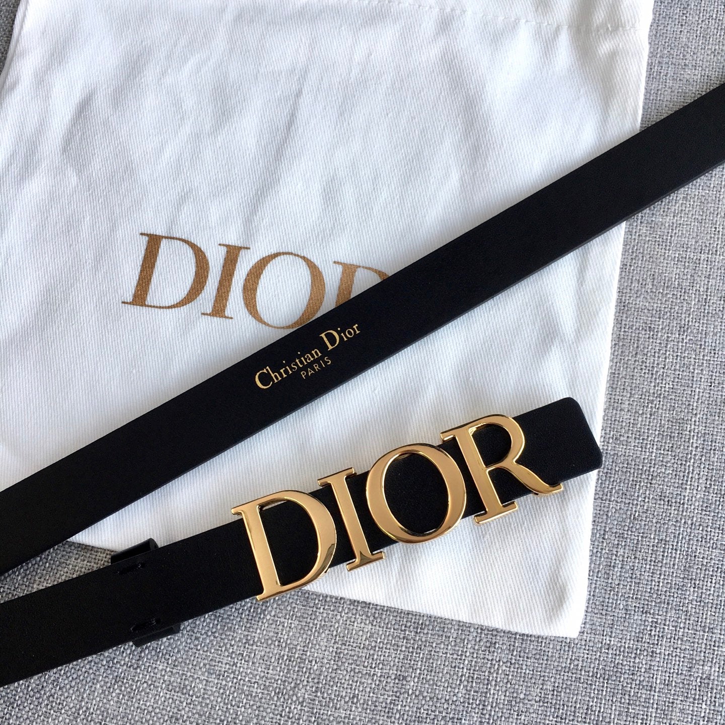 Black leather belt with gold-tone Dior logo buckle and visible strap holes