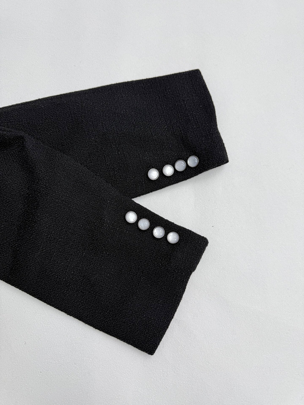 Black Louis Vuitton jacket cuffs with four silver buttons each