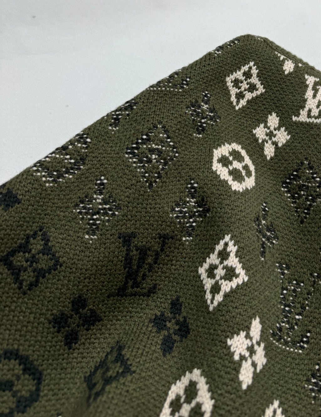 Green knit sweater knit texture with white and blue monogram motifs