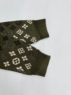 Green knit sweater sleeve cuffs with monogram motifs, ribbed cuffs