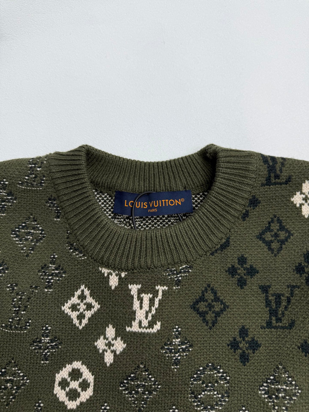 Green knit sweater collar with monogram pattern and ribbed crew neck
