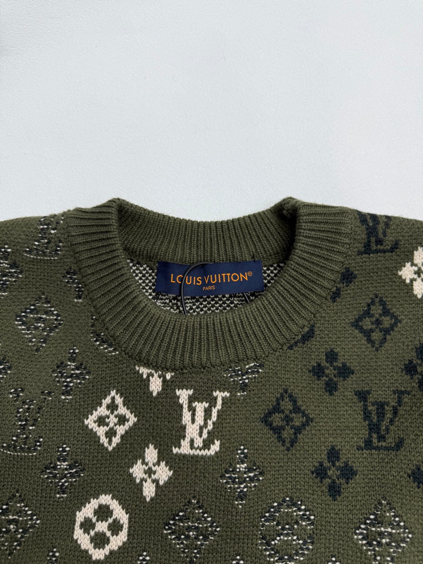 Green knit sweater collar with monogram pattern and ribbed crew neck