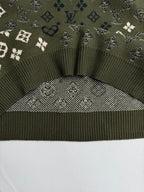 Green knit sweater hem with ribbed trim and monogram knit yoke