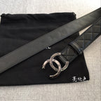 Black leather belt with wide strap and metal interlocking buckle on quilted panel