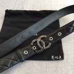 Black quilted belt with wide strap and metal interlocking buckle detail
