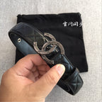 Black quilted leather belt with metal clasp buckle, shown in a hand