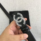 Chanel belt with rhinestone CC buckle detail on black strap, shown in close-up.