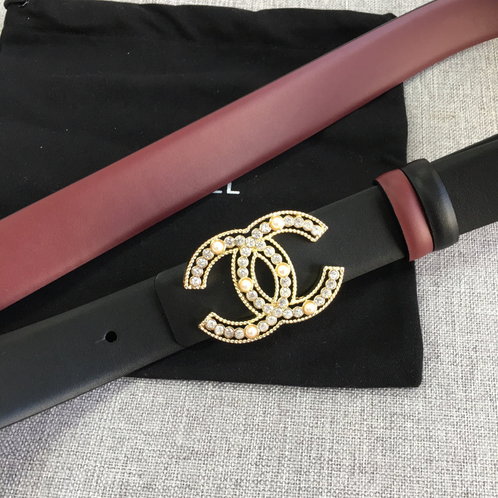 Chanel belt laid flat with black strap, burgundy edge, and gold CC logo buckle