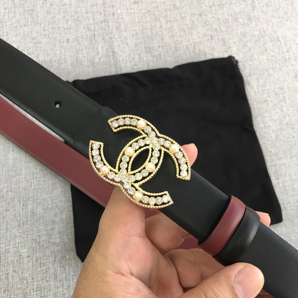 Chanel belt with black strap, burgundy edge, and gold jeweled CC logo detail