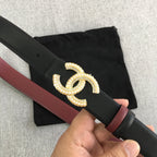 Black belt with burgundy trim and gold-tone CC logo buckle close-up