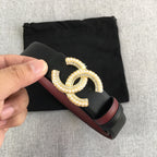 Black belt with burgundy trim and gold-tone CC buckle, held in hand