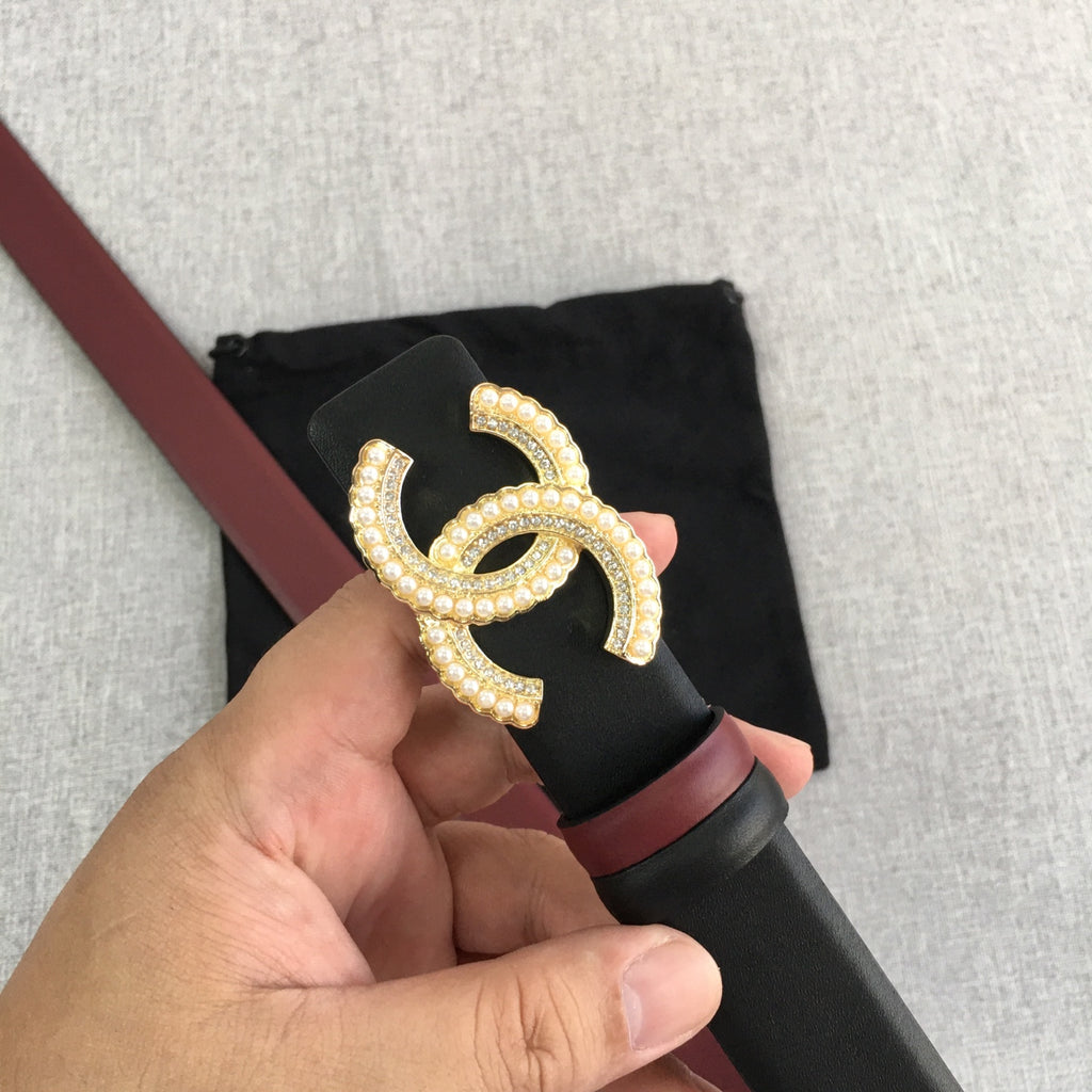 Black belt with burgundy trim and large gold-tone CC logo buckle