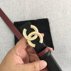 Black belt with burgundy trim and large gold-tone CC logo buckle