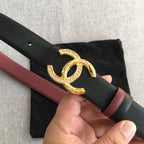 Black Chanel belt with maroon edge trim and gold-tone CC buckle, rhinestone studded