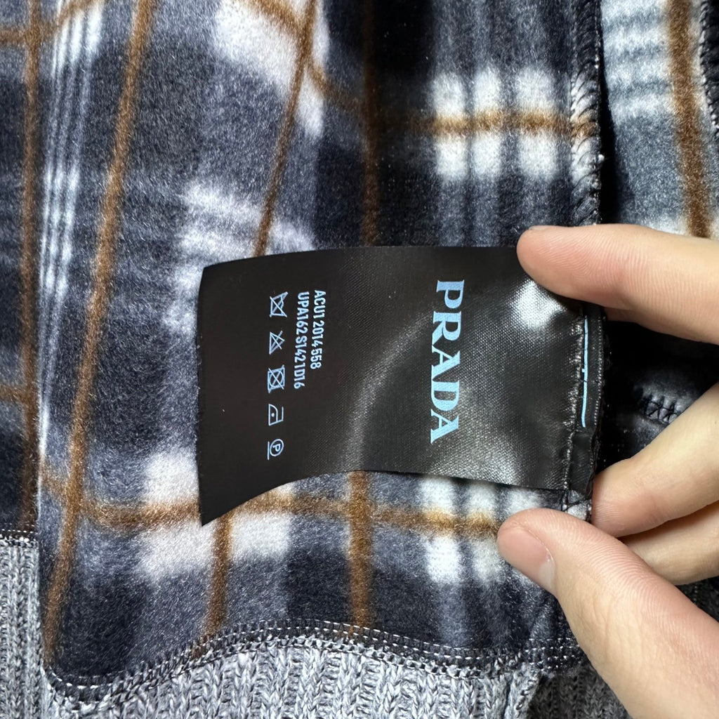 Plaid interior lining with PRADA care label on grey knit jacket