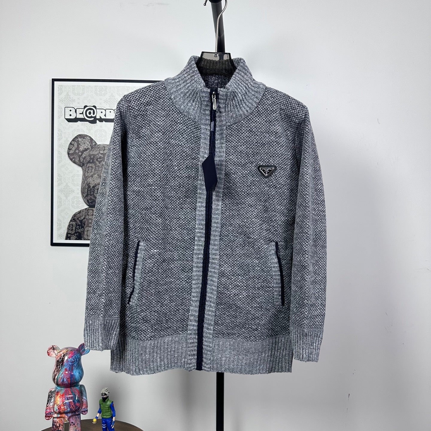 Grey textured knit full-zip jacket with mock neck and small triangle chest logo