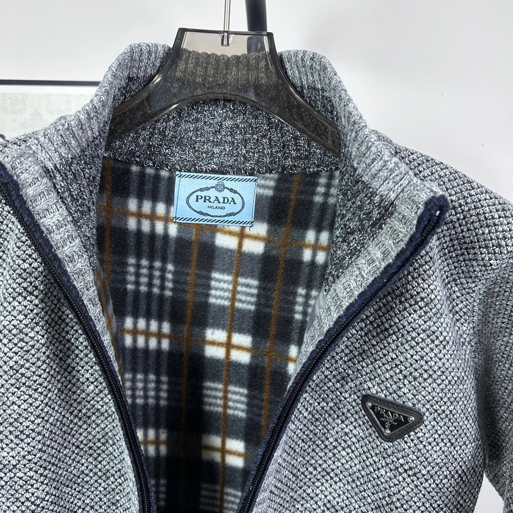 Grey knit full-zip jacket with plaid-lined interior collar and triangle chest logo