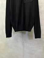 Black long-sleeve sweater hem and cuffs with ribbed knit detailing