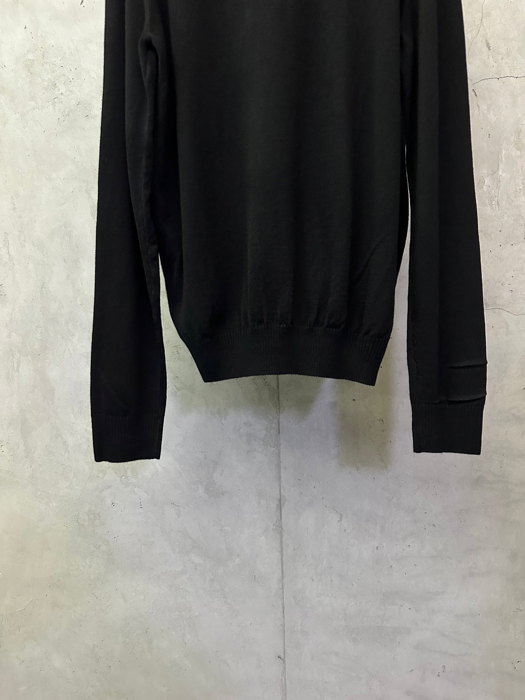 Black long-sleeve sweater back view with ribbed hem and cuffs