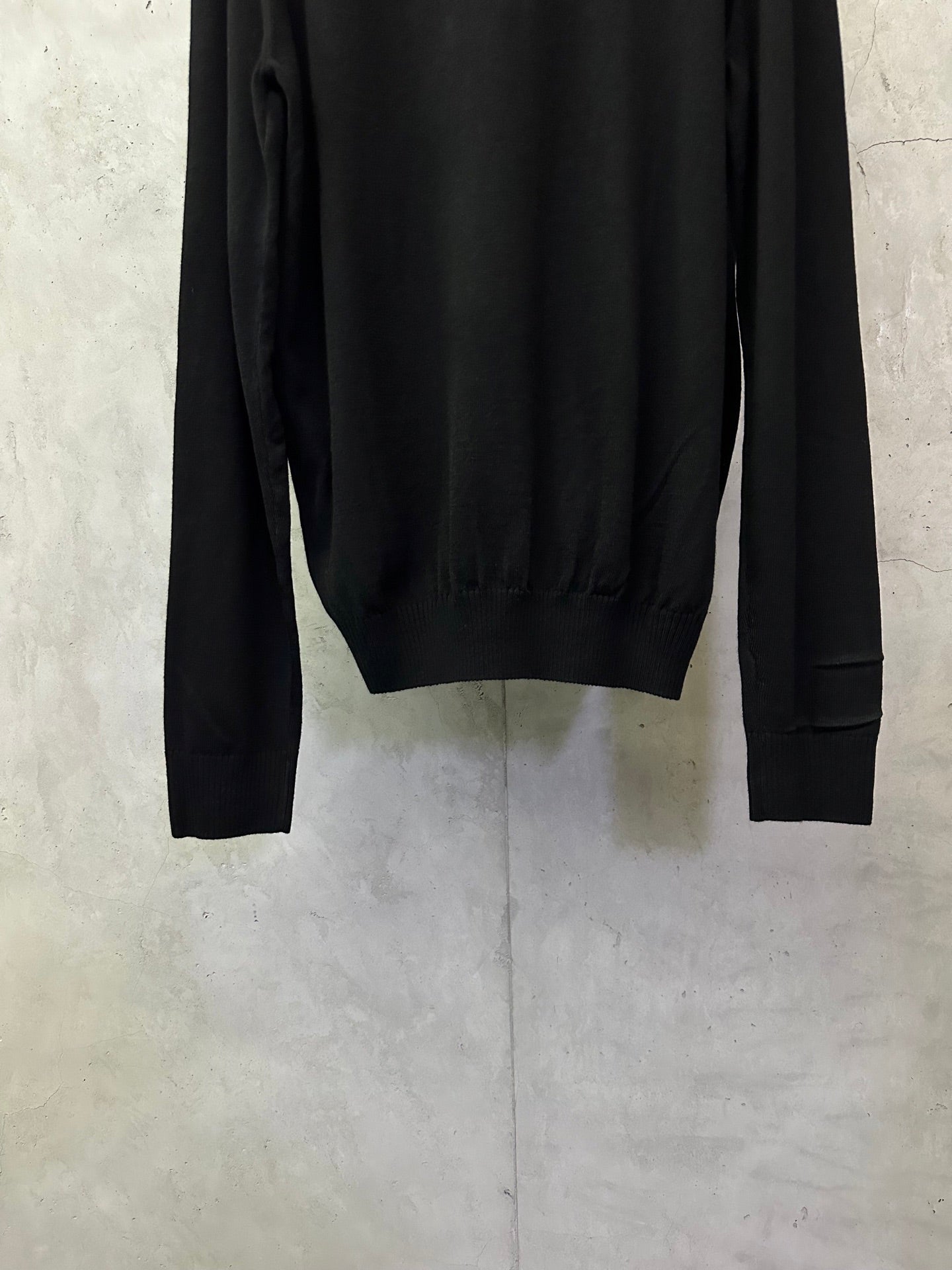 Black long-sleeve sweater back view with ribbed hem and cuffs