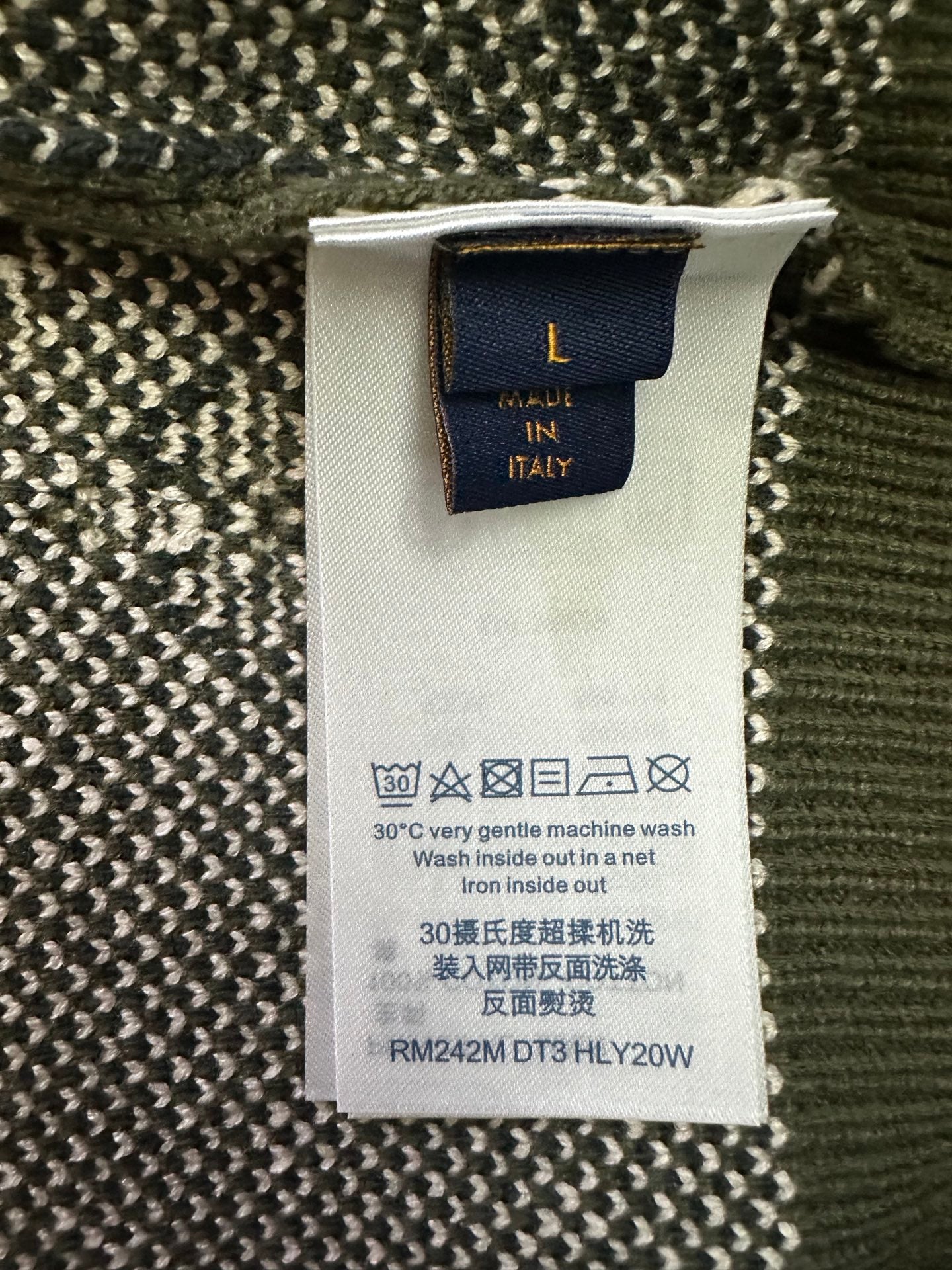 Garment care label tag on knit sweater, wash and iron instructions