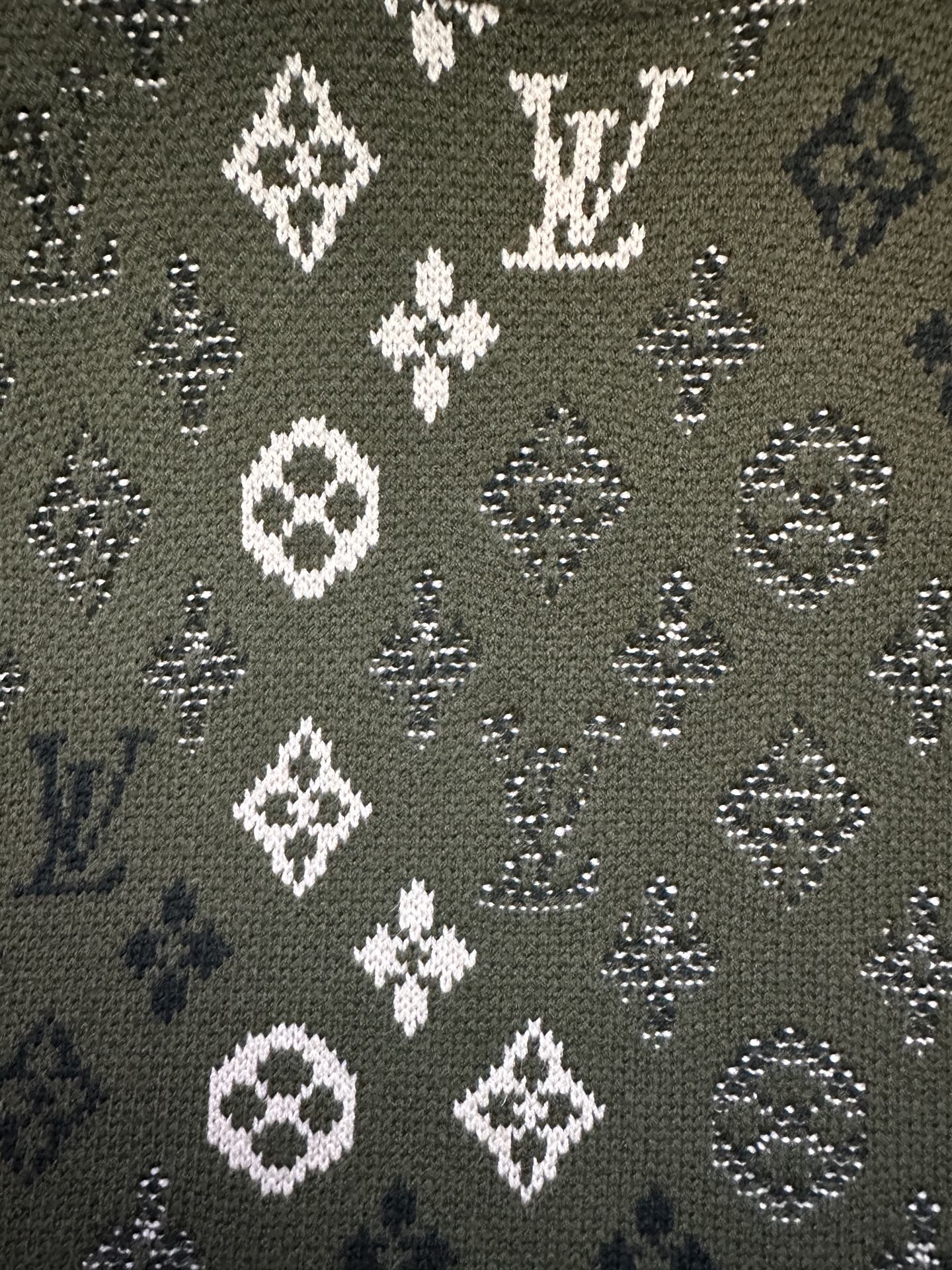Long-sleeve sweater pattern close-up, olive knit with white diamond and monogram icons
