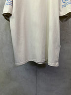 Off-white crewneck T-shirt hem and curved bottom with partial blue sleeve logo