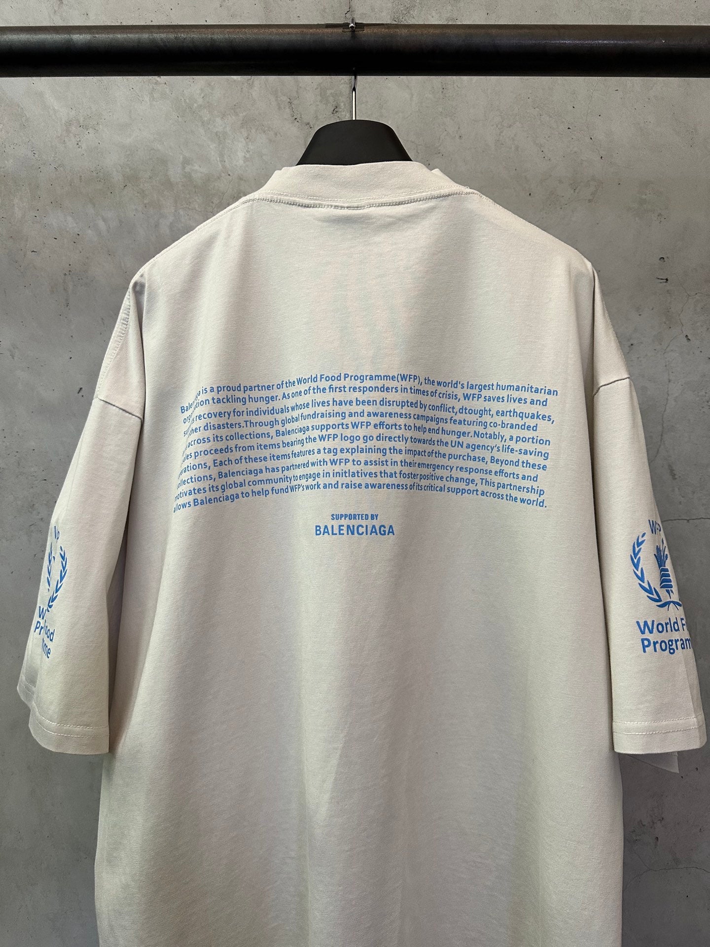 Off-white crewneck T-shirt back with dense blue text and small BALENCIAGA mark