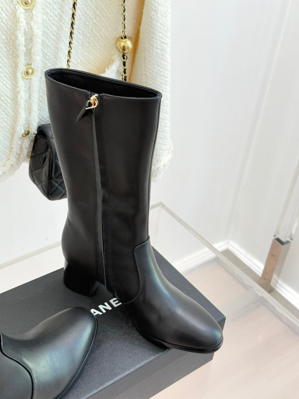 Chanel leather tall boots with gold CC hardware, standing on display box