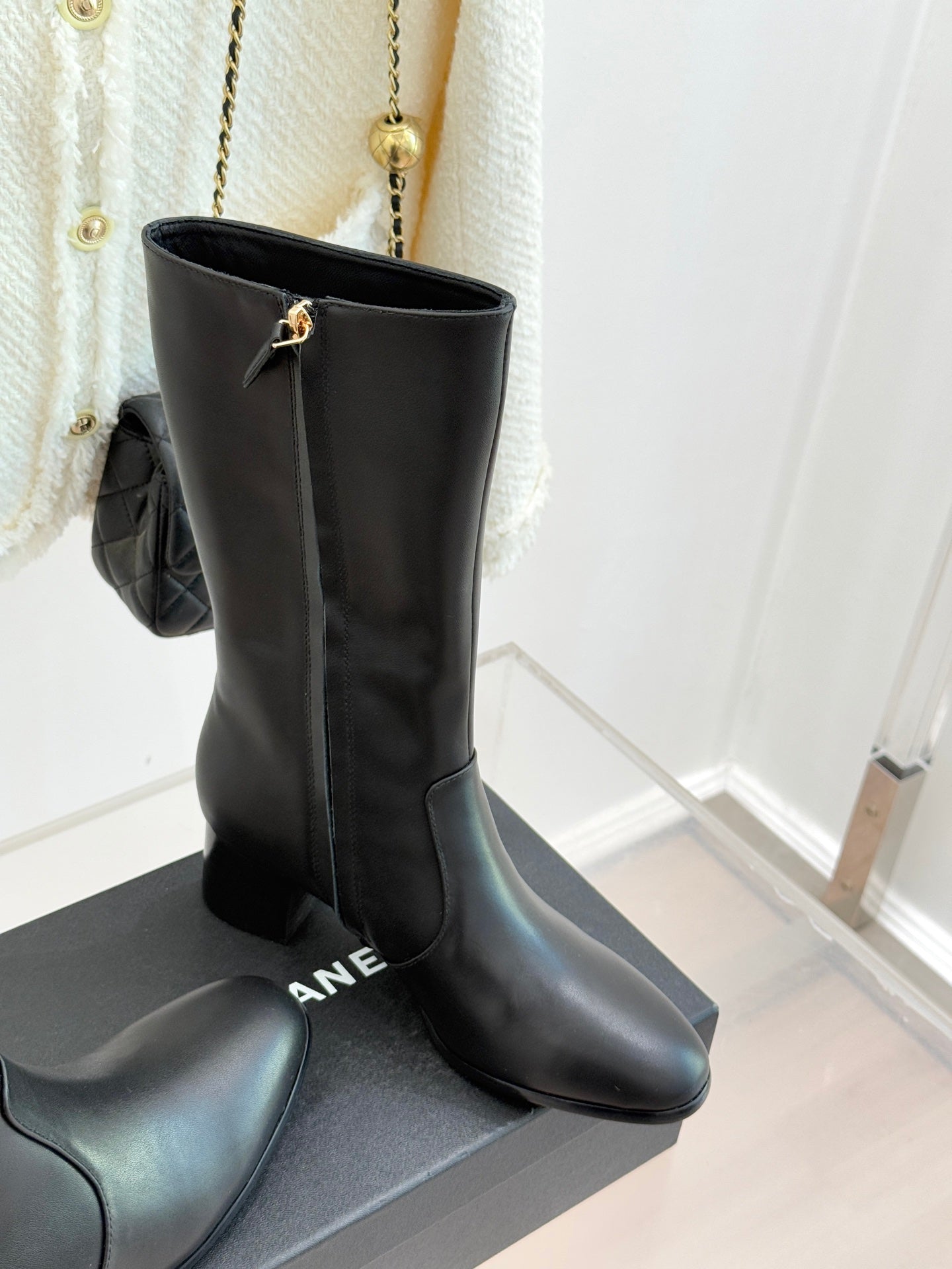 Chanel leather tall boots with gold CC hardware, standing on display box