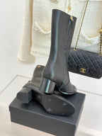 Chanel leather tall boots with sculpted block heel on display stand