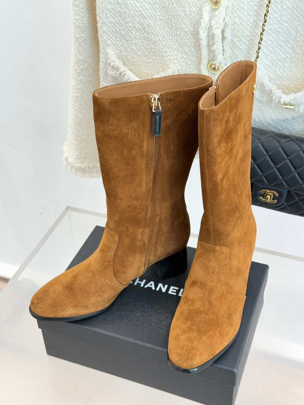 Pair of tan suede heeled ankle boots with zipper and pointed toe