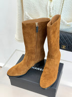 Pair of tan suede heeled ankle boots with zipper and pointed toe