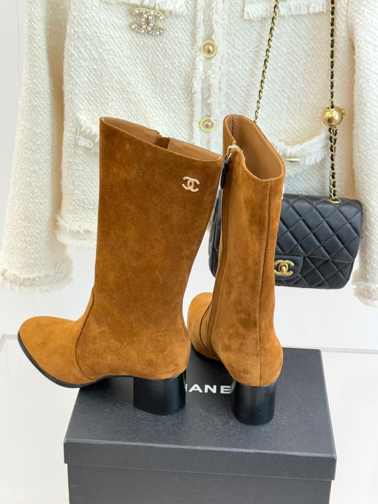 Tan suede tall ankle boots with CC logo detail, stacked heel, and side zipper